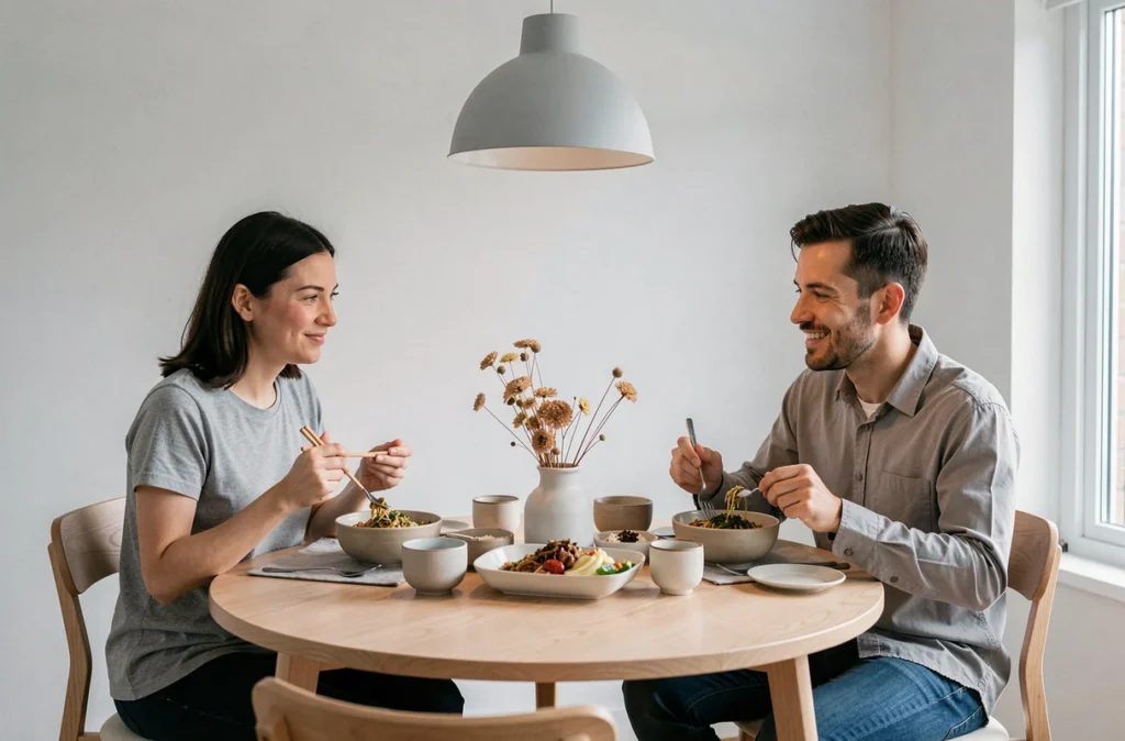 Couple mangeant lentement ensemble à la maison, partageant un repas équilibré dans une ambiance détendue