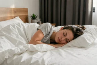 Femme dormant paisiblement dans une chambre moderne, illustrant l'importance du sommeil pour la gestion du poids corporel